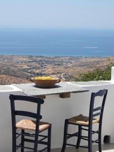 a bowl of fruit sitting on a table with two chairs at The Artist House in Triandáros