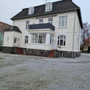 a large white house sitting on top of a driveway at Patriciavilla tæt på centrum in Haderslev
