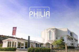 a white building with a sign that reads phili restaurant bar at Philia Hotel in Podgorica
