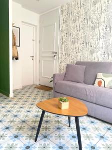 a living room with a couch and a table at Casita Valence - Petite maison de charme - Parking gratuit & Jardin Privé in Valence