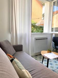 a living room with a couch and a window at Casita Valence - Petite maison de charme - Parking gratuit & Jardin Privé in Valence +22 photos
