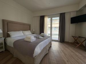 a hotel room with a bed with towels on it at Acropolis Divine Apartments in Athens +51 photos
