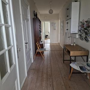 a hallway with a door and a wooden floor at Patriciavilla tæt på centrum in Haderslev