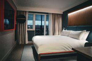 a bedroom with a large white bed and a window at Village Hotel Reading in Reading +34 photos