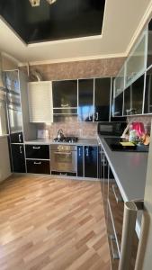 a kitchen with black cabinets and stainless steel appliances at Bright House in Bila Tserkva +11 photos