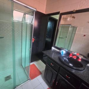a bathroom with a sink and a glass shower at Apto 1,5 km do Shop. Manauara in Manaus +39 photos