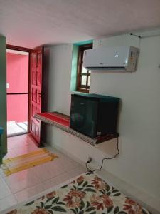 a room with a tv on a wall with a window at Suites Helena in Ilhabela +63 photos