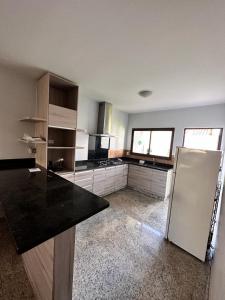 an empty kitchen with a refrigerator in a room at Casa mobiliada BR 153 in Aparecida de Goiânia