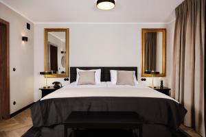 a bedroom with a large bed with two tables and two mirrors at Dethloff Art Residence in Warsaw