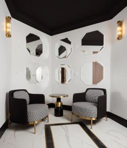 two chairs and a table in a room with mirrors at Dethloff Art Residence in Warsaw