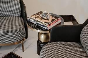 a table with a stack of books on it next to two chairs at Dethloff Art Residence in Warsaw +62 photos