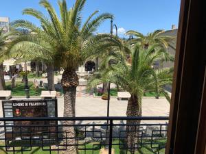 a view of palm trees from a hotel window at Arega Rooms in Villasimius
