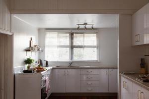 a kitchen with white cabinets and a window at Croftby Hills - Scenic Rim in Croftby