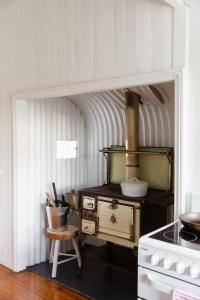 a kitchen with an old stove and a chair at Croftby Hills - Scenic Rim in Croftby