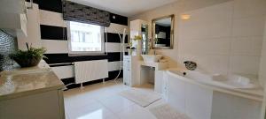 a white bathroom with a tub and a sink at Indira Vendégház in Nyíregyháza +39 photos
