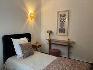 a small bedroom with a bed and a lamp at Hotel U Campanile in Vivario