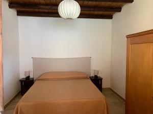 a bedroom with a bed and a chandelier at Arega Rooms in Villasimius