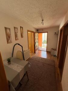 an empty living room with a table and a door at Vila AT in Sarajevo