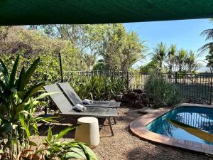 a garden with a bench and a swimming pool at Jungle Hut - RARE absolute beachfront! in Dundee Beach