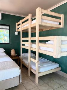 a bedroom with two bunk beds and a green wall at Jungle Hut - RARE absolute beachfront! in Dundee Beach +34 photos