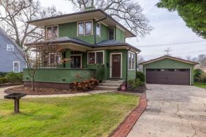 a green house with a garage in a yard at Historic Home with King Bed in High Point