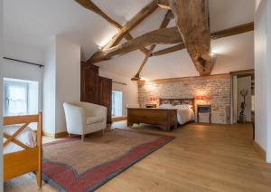 a bedroom with a bed and a brick wall at Le Logis D'Azé in Azé