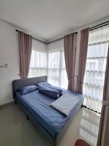 a bed with blue pillows in a bedroom with windows at Athara Residence in Tlekung +85 photos