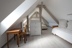 a bedroom with a desk and a bed in a attic at La maison bleue in Lusigny-sur-Barse