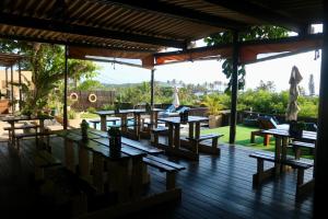 a group of tables and chairs on a wooden deck at Planet Scuba Bed and Breakfast in Ponta do Ouro