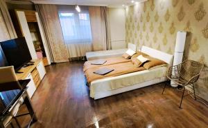 a bedroom with a bed and a desk and a television at Indira Vendégház in Nyíregyháza