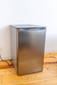 a stainless steel refrigerator sitting on top of a wooden floor at Suites - Elevador da Bica in Lisbon +24 photos