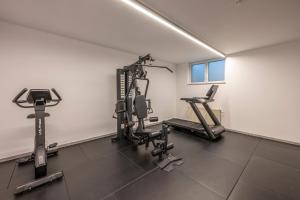 a gym with treadmills and machines in a room at Hotel Falko in Meise