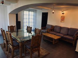 a living room with a glass table and a couch at Vila Antanta Podu' Cu Lanturi in Bacău +23 photos