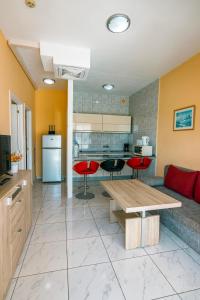 a kitchen and living room with red chairs and a table at Aparthotel MONTERREY in Puerto Rico de Gran Canaria