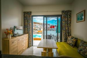 a living room with a couch and a table and a window at Aparthotel MONTERREY in Puerto Rico de Gran Canaria