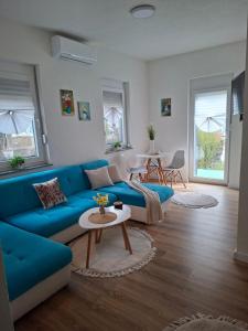 a living room with a blue couch and a table at Apartman Hana in Bihać