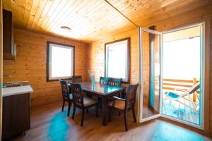 a dining room with a table and chairs and windows at Marepromo Žirje in Žirje