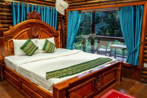 a bedroom with a wooden bed with a large window at Greenhouse Retreat in Senmonorom +137 photos
