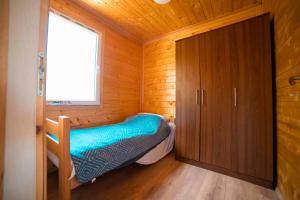 a small bedroom with a bed in a wooden cabin at Marepromo Žirje in Žirje
