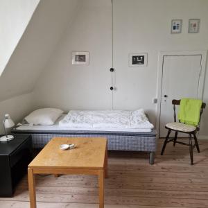 a bedroom with a bed and a chair and a table at Patriciavilla tæt på centrum in Haderslev