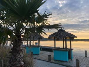 a boardwalk with tables and umbrellas next to the water at Snug Harbor Marina and Resort in Chincoteague