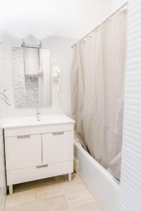 a white bathroom with a sink and a shower at Suites - Elevador da Bica in Lisbon