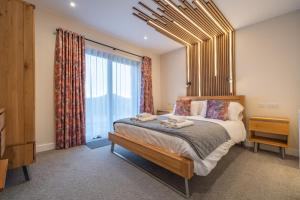 a bedroom with a bed and a large window at Parklands in Penrith