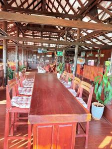 a long wooden table and chairs in a room at Greenhouse Retreat in Senmonorom