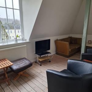 a living room with a tv and a couch at Patriciavilla tæt på centrum in Haderslev