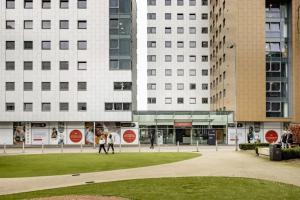 two people playing with a frisbee in front of buildings at Fitzroy Court near Luton Airport in Luton