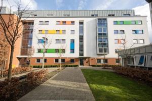 a large white building with colorful windows and a lawn at Fitzroy Court near Luton Airport in Luton