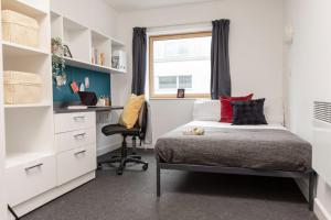 a bedroom with a bed and a desk and a window at Fitzroy Court near Luton Airport in Luton +17 photos