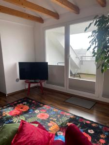 a living room with a tv and a large window at Fewo extraschön - Dachgeschoss in Lindau