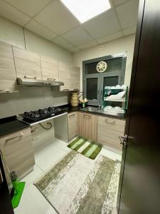 a kitchen with a sink and a stove in it at Farno Hostel in Muscat